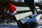 Abandoned snowy park bench with Santa hat for Christmas spirit.