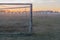 Abandoned soccer field and old rusty goals on sunset