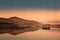 Abandoned stone building reflected in lake at sunset