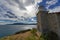 Abandoned stone lighthouse under a dramatic sky, Greece.