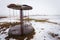 Abandoned swing carousel with broken chains in winter