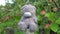 Abandoned Toys grey sad bear sitting on old style country side fence with green apple tree on background. No one around