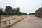 Abandoned tracks next to a functioning railroad seen from a clearing of a railroad station on a cloudy day in the italian