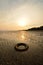 Abandoned tyre on the beach when the sun goes down