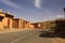 Abandoned village of clay houses along empty road in Atlas mountains, Morocco