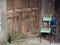 Abandoned village doorway with chair and wine bottle. Poignant.