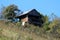 Abandoned vintage retro wooden vineyard cottage on concrete foundation with front balcony and broken roof tiles on side of small