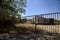 Abandoned warehouse behind a closed gate on a sunny day in the countryside