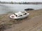 Abandoned white boat on bank of river Sava with panoramic view of Belgrade