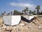 Abandoned white painted concrete bunkers in paphos cyprus dating from the civil war era with rocks on the beach next to palm trees