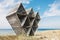 Abandoned wooden geometric sculpture on wild beach
