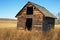 Abandoned wooden granary in grassy field