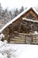 abandoned wooden log house during snowstorm