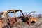 Abandoned wreckage of an yellow Soviet Russian car in the middle of dry hay in Southern Armenia