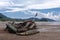 Abandoned wrecked fishing boat by the sea on a cloudy day. Scenic sea-side view.