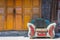 Abandonned couch in a chinese village in front of a yellow door