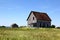 Abandonned farmhouse with shed in a field