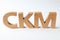 Abbreviation CKM Customer Knowledge Management made of letters on white wooden table