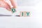 The Abbreviation DIY Formed By Wooden Blocks And Arranged By Male Fingers On A White Table