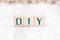 The Abbreviation DIY Formed By Wooden Blocks On A White Table