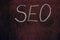 The abbreviation `SEO` on a vintage burgundy background