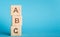 ABC letters of wooden blocks in pillar form on blue background