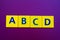 ABCD spelling on yellow plastic cubes