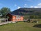 Abiskojaure, Norrbotten, Sweden, Agust 23, 2019: young hiker resting at piknic table at red AbiskoJaure STF hut. Green hills,