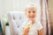 Aborable smiling blonde 3 years baby girl eating homemade ice cream and laughing