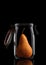 ABosc Pear inside a glass storage or canning jar isolated on black with reflection, with lid open