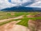 From above, the agricultural fields nestled amidst towering mountains in Greece create a stunning aerial view