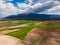 From above, the agricultural fields nestled amidst towering mountains in Greece create a stunning aerial view