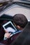 Above head perspective of a businessman working on his tablet while sitting in his black limo