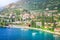 Above idyllic Lake Garda with sailboats in Malcesine at sunrise, Italian alps