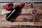 From above layout of grapes and walnuts flying from wine bottle into transparent wineglass on wood background