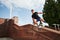 Above the obstacle. Young sports man doing parkour in the city at sunny daytime