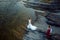 Above outdoor wedding portrait of the beautiful newlyweds looking at each other while standing at the river bank.