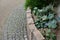 Above the palisade of wooden sleepers are planted ornamental perennials and a very nice dwarf bamboo. arch by the road made of cob