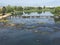 Above the river surface, there is a dam made of stones