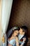 Above romantic wedding portrait. The handsome groom is tenderly hugging and kissing his beautiful brunette bride in the