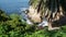 From above sea cave in La Jolla Cove. Lush foliage and sandstone grotto. Rock in pacific ocean lagoon, waves near steep cliff.