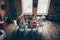 Above top high angle view of noel evening family gathering in loft living room. Grey-haired grandparents, brother boy