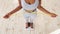 Above view of African American lady measuring her waist with tape, standing on scales indoors, closeup