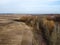 From above, the view captures the harmonious coexistence of an agricultural field and a forest, creating a picturesque landscape