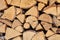 Above view of chopped firewood, logs stacked together in storage pile. Closeup of wooden background and texture