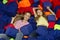 Above view of happy mom with her daughter lying among soft cubes at childrens amusement park