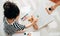 Above view image of a little girl kid painting on the easel at home. Schoolgirl sitting on the carpet and drawing in her room