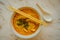 Above view of penang asam laksa rice noodle in white bowl with chopsticks on white table with spicy fish tamarind soup