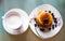 Above view of plate with cup of creamy coffee and the plate with sweet pancakes covered by blueberries fruits and maple sirup