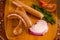 Above view of sausages inside of a plastic bags and vegetables, tomato, garlic, green pepper and onion and rosemary